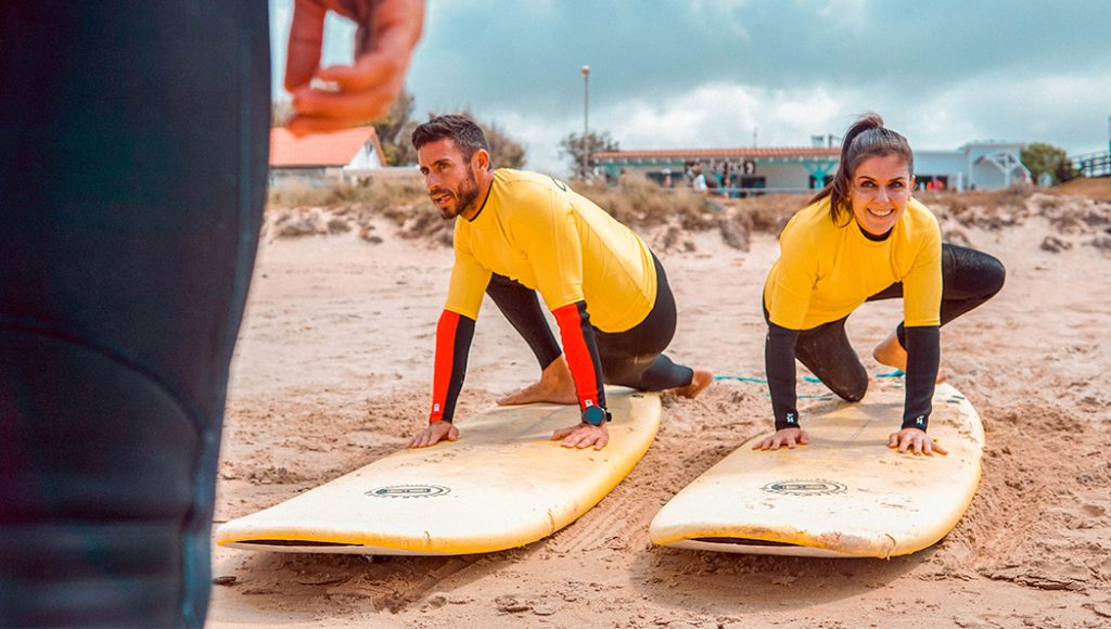 Instructores practicando el pop-up en la arena antes de entrar al agua